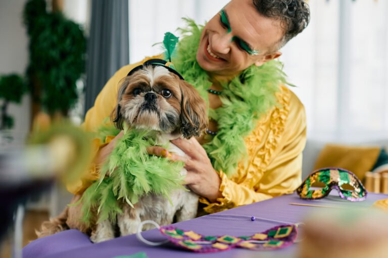 Happy man and his dog dressed up for Mardi Gras carnival.